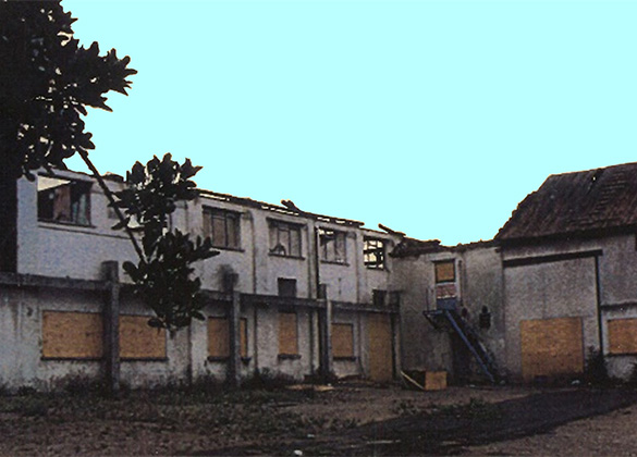 A burnt-out building with boarded up windows.