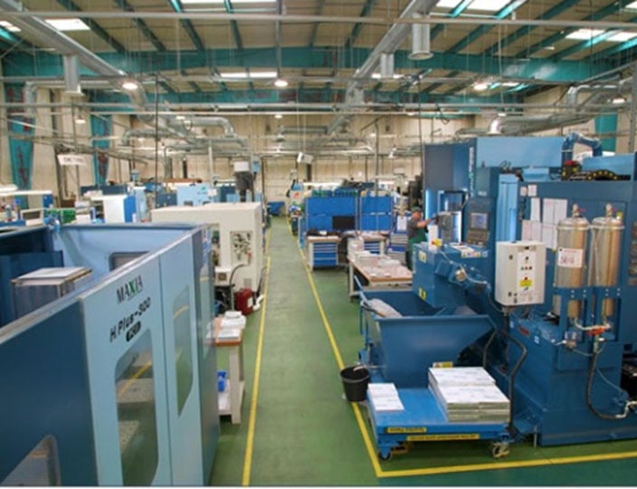 View looking down at a large factory floor with milling machines.