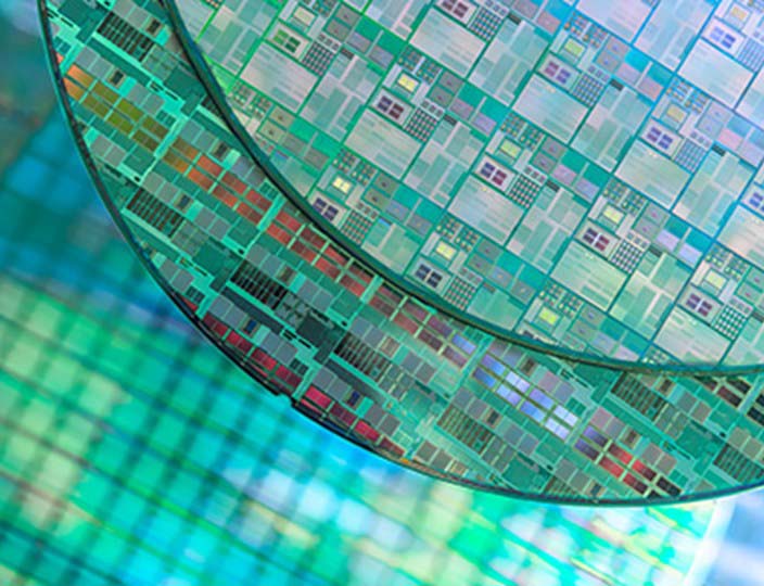 Colourful image of etched silicon wafers reflecting patterns of light.